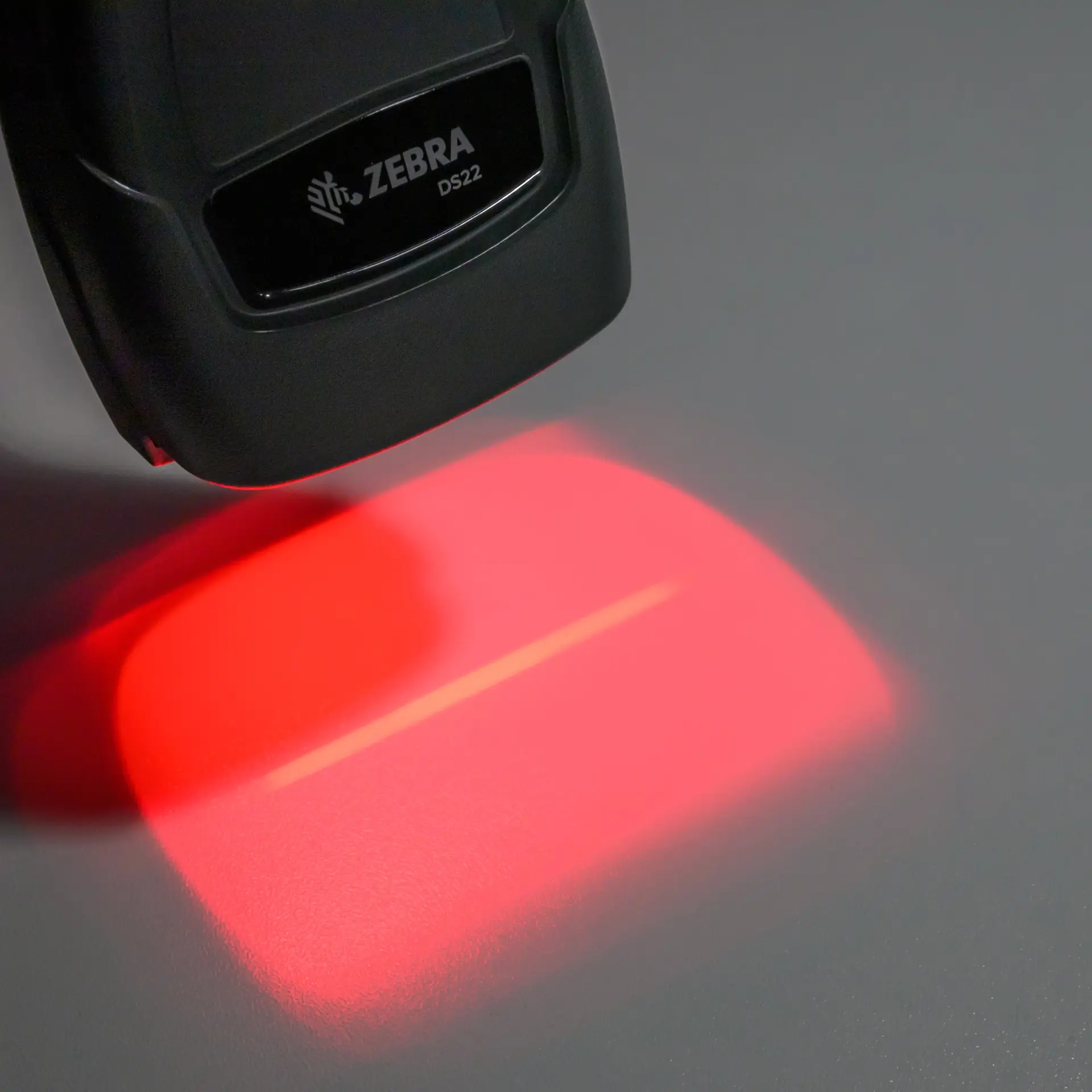 arcode Scanner Zebra DS22-Serie – schräge Nahaufnahme, rotes Scanlicht aktiv, Front mit Zebra-Logo sichtbar