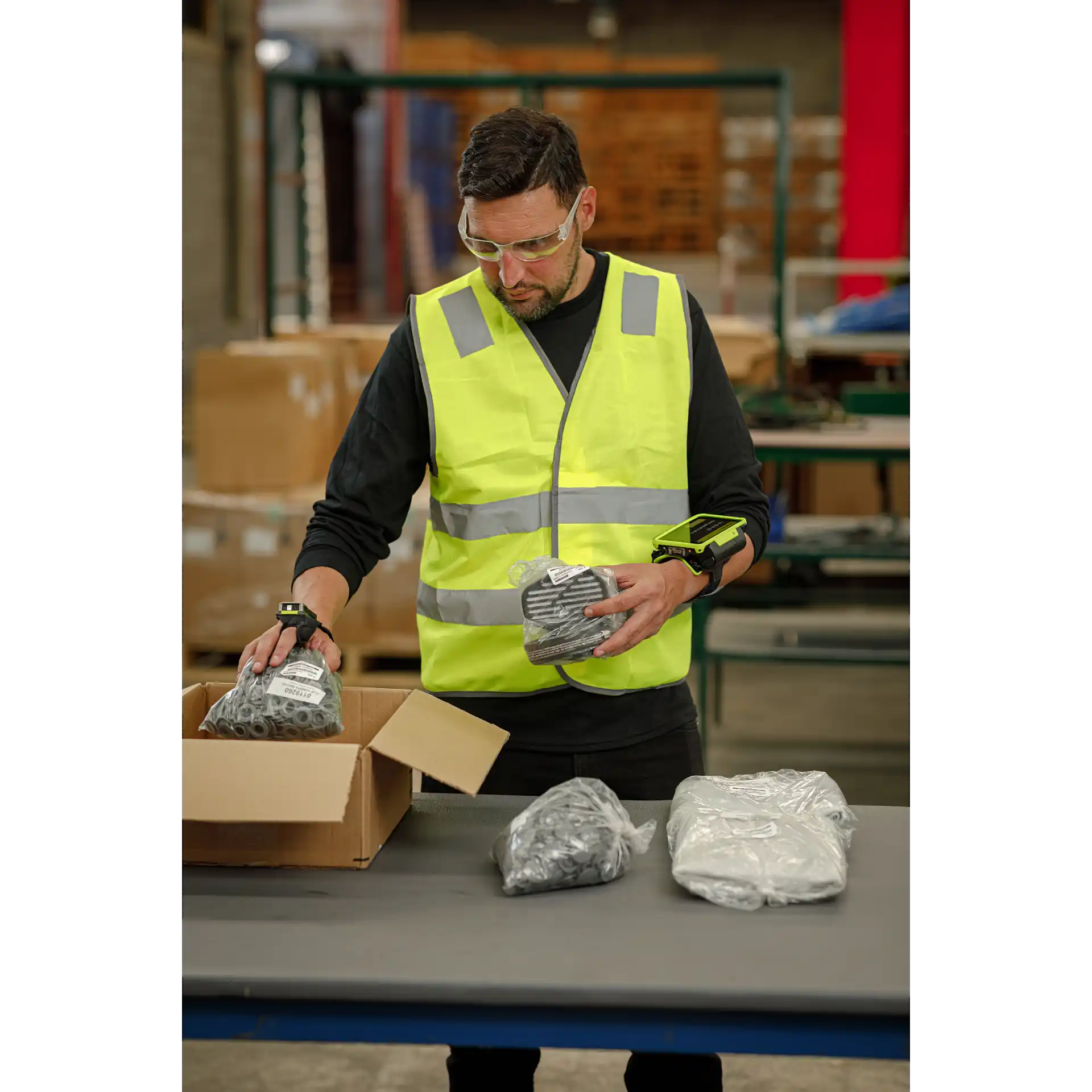 Wearable Zebra WT6400 – vorne am Packtisch mit RS5100 und eingeschaltetem Display beim Sortieren