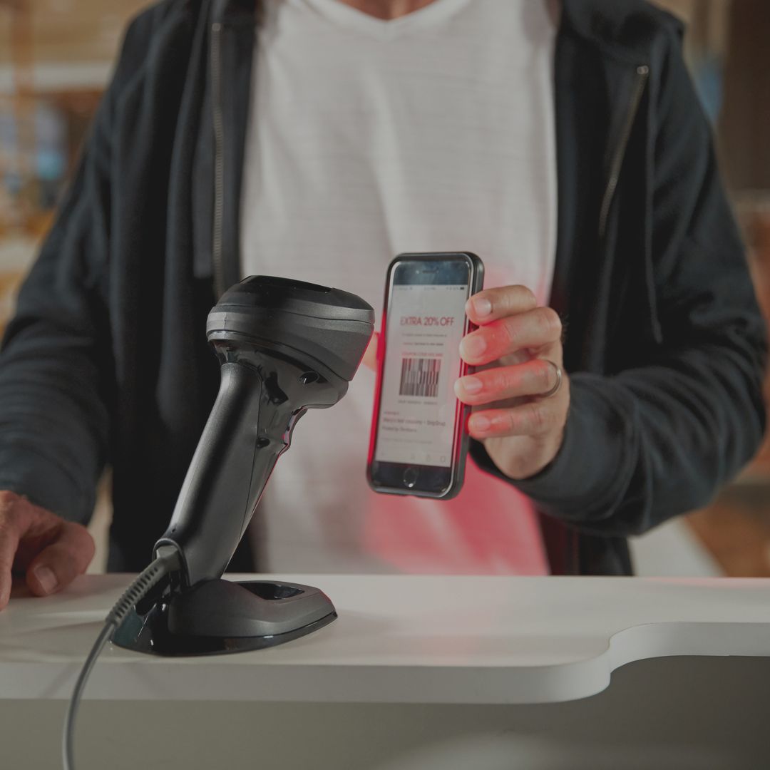 Eine Frau scannt mit einem Barcode-Scanner ein Paket