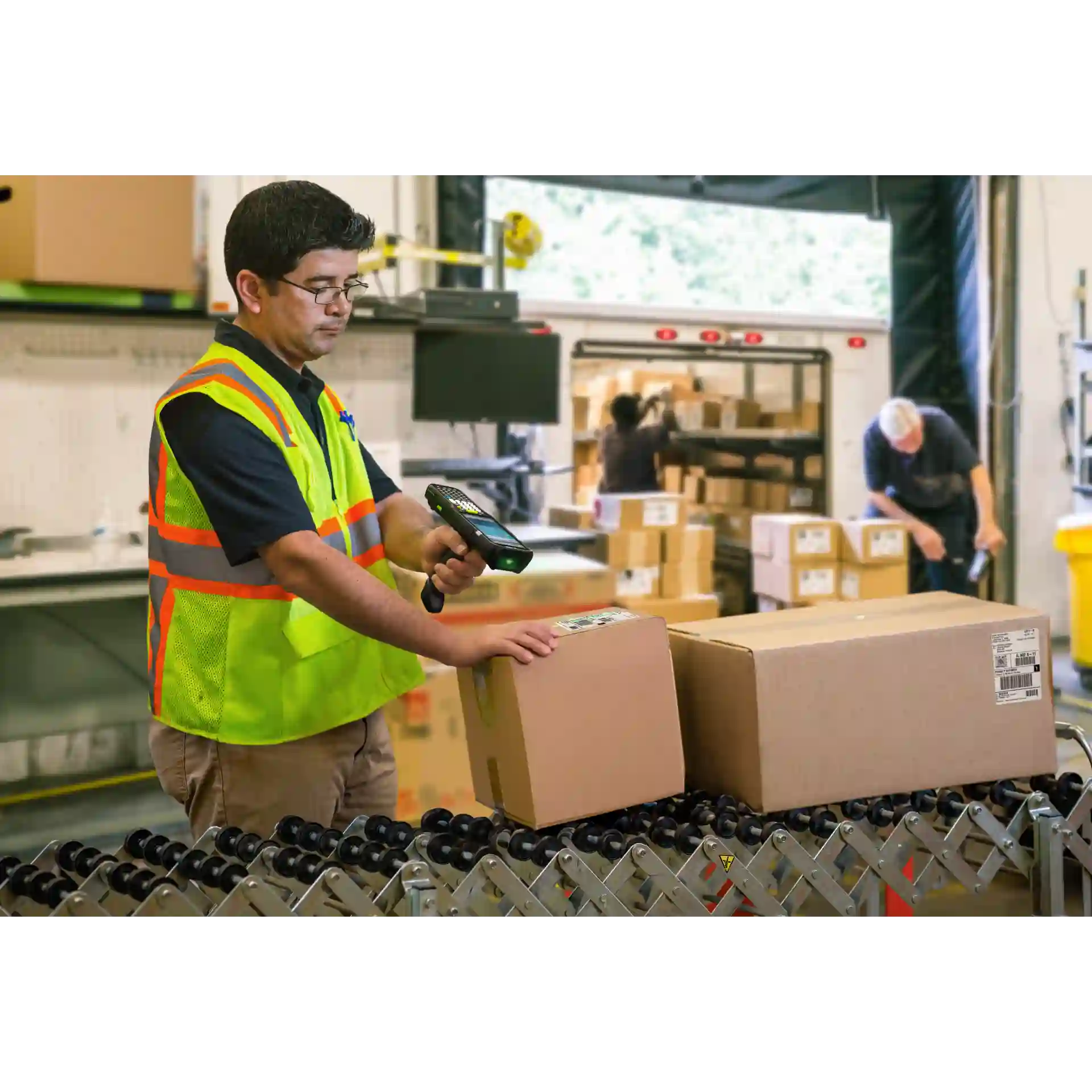 MDE Gerät Zebra MC3400/MC3450 mit Pistolengriff scannt Pakete im Versand, Display und Scanner an.