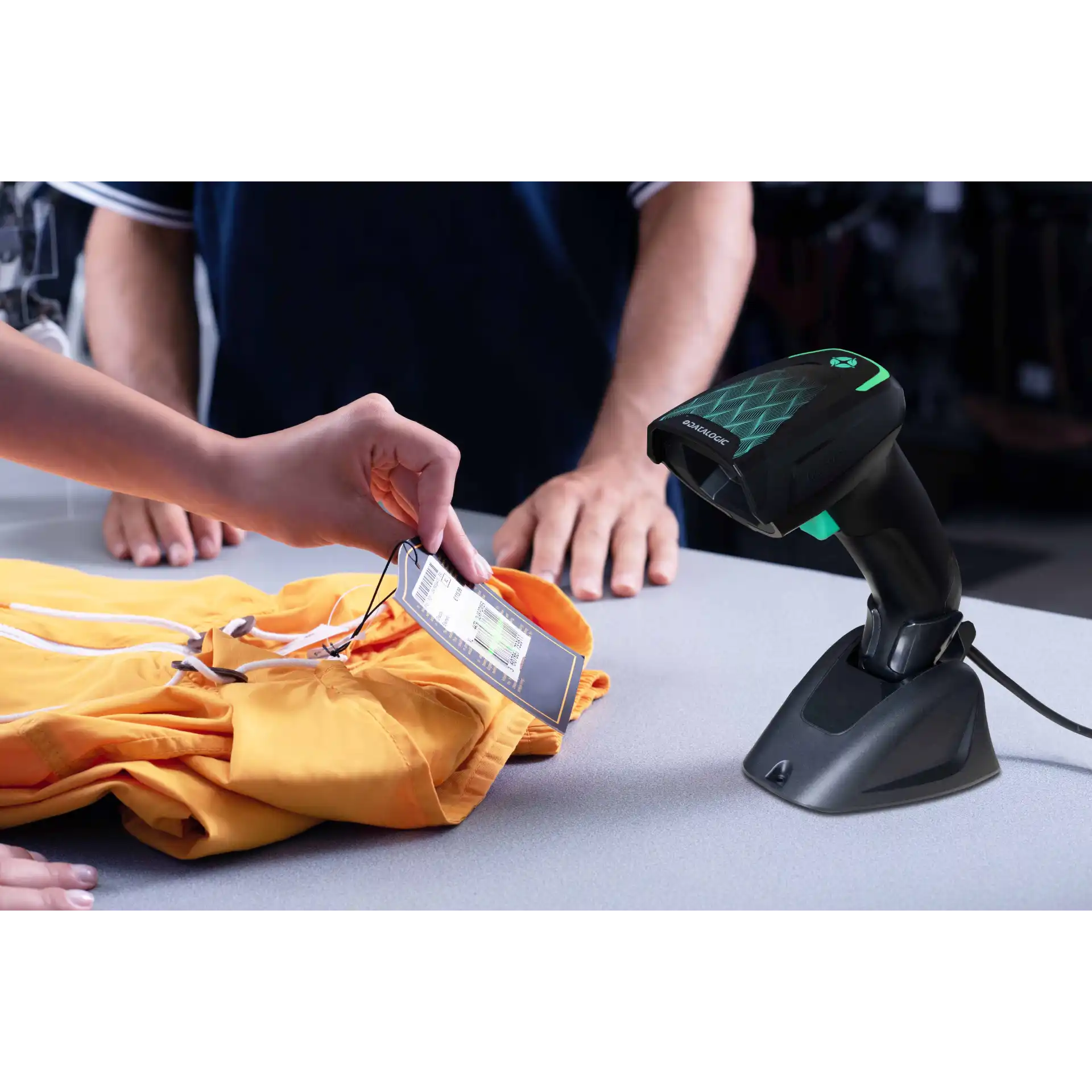 Barcode Scanner Datalogic Gryphon 4600 Serie im Präsentationsmodus auf Standfuß, scannt Etikett an Kleidung, Frontansicht mit Leuchtfeld