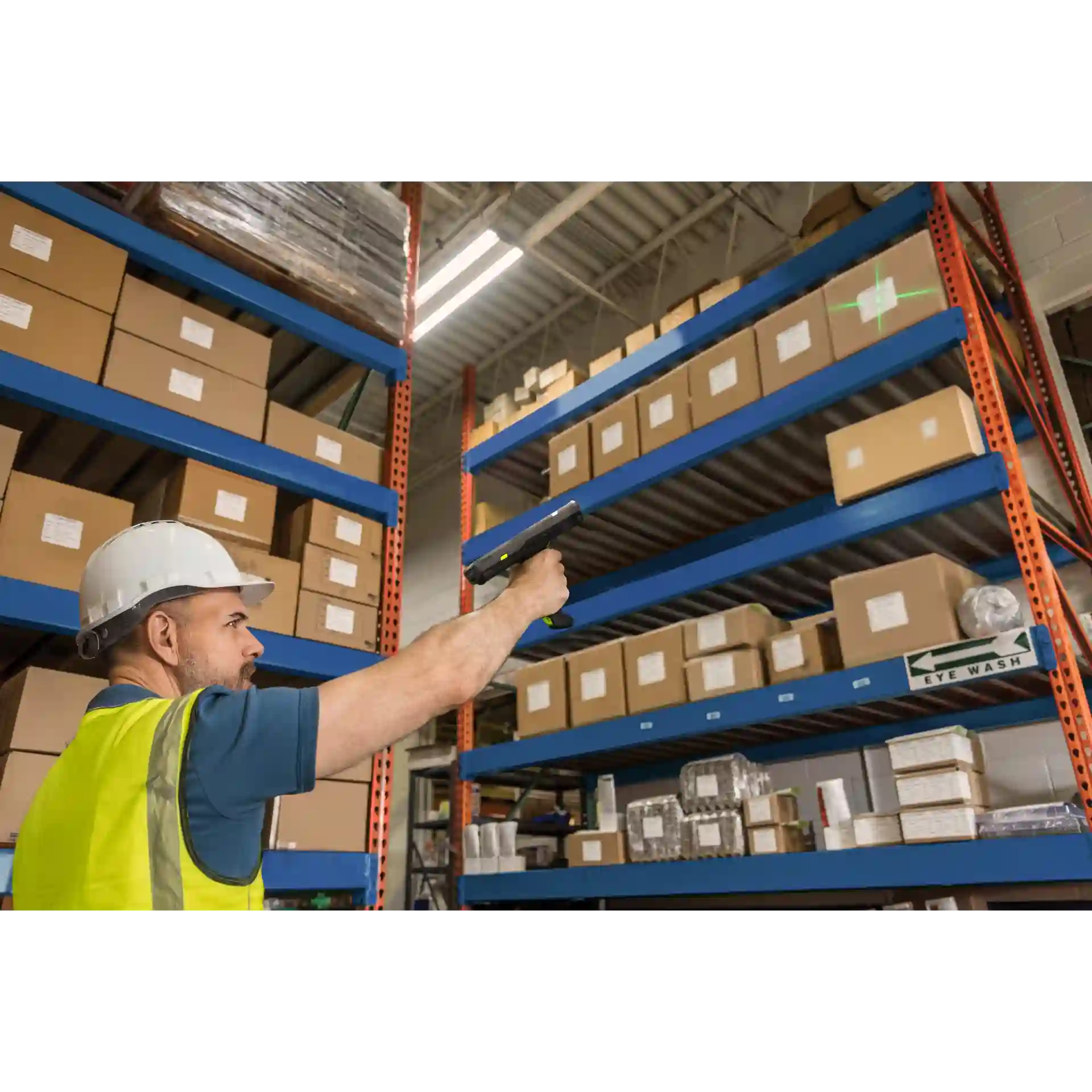 MDE Gerät Zebra MC3400/MC3450 mit Pistolengriff scannt im Hochregallager, Griff und Zielkreuz des Scanners sichtbar.