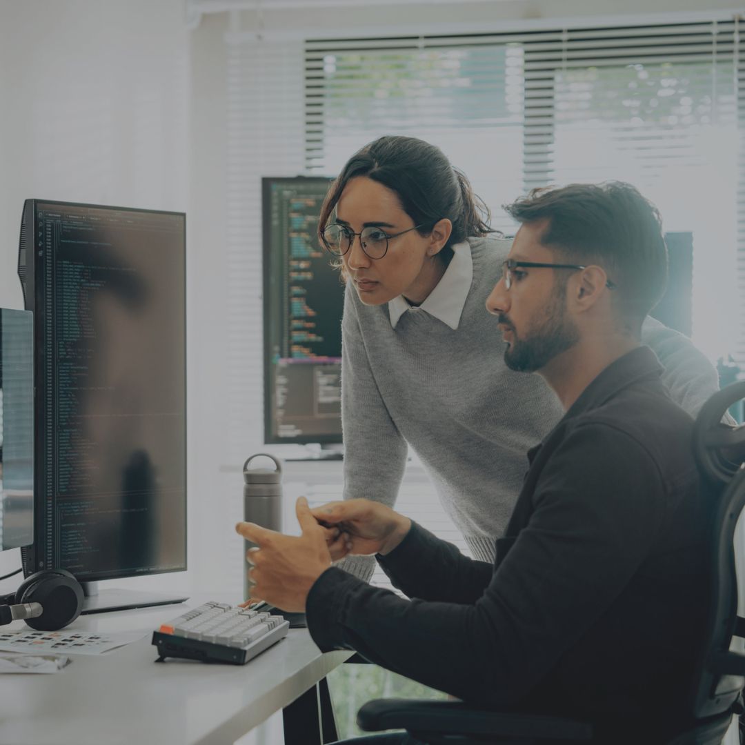Zwei Menschen im Büro vor einem Schreibtisch
