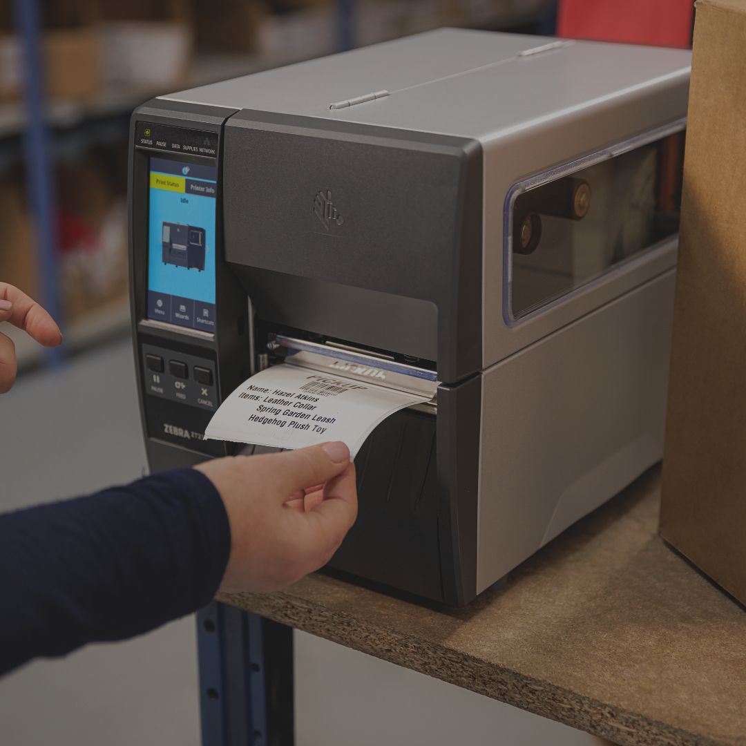 Ein Zebra Etikettendrucker aus dem ein Etikett entnommen wird.