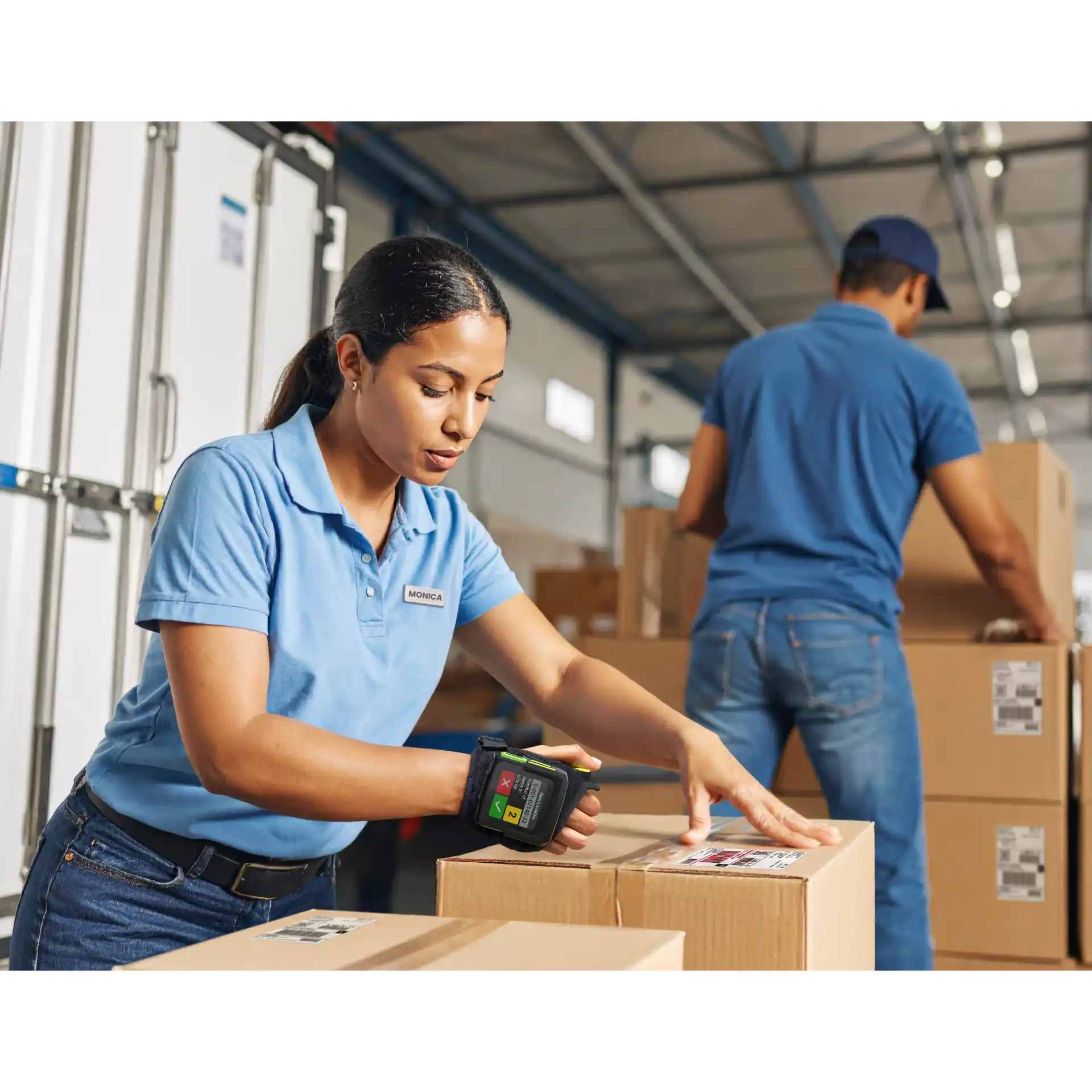 Wearable Zebra WS50-WS501 – Nutzerin scannt Karton, Display aktiv, Knöpfe sichtbar