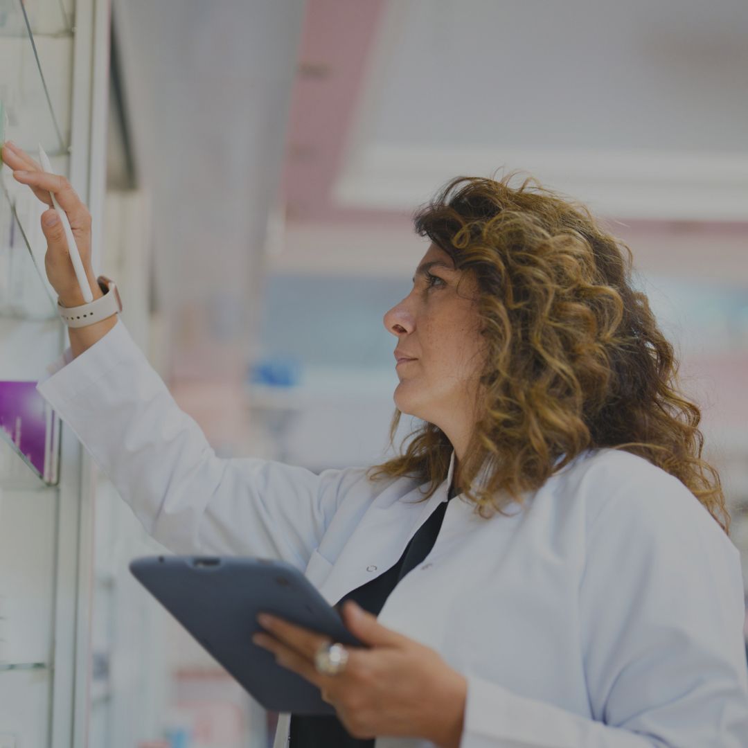 Eine Ärztin die etwas aus einem Schrank nimmt.